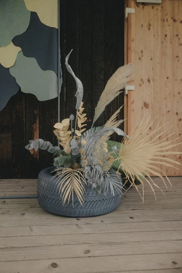 dans un pneu bleu se trouve une composition artistique de fleurs jaune et bleue de la même couleur que le pneu