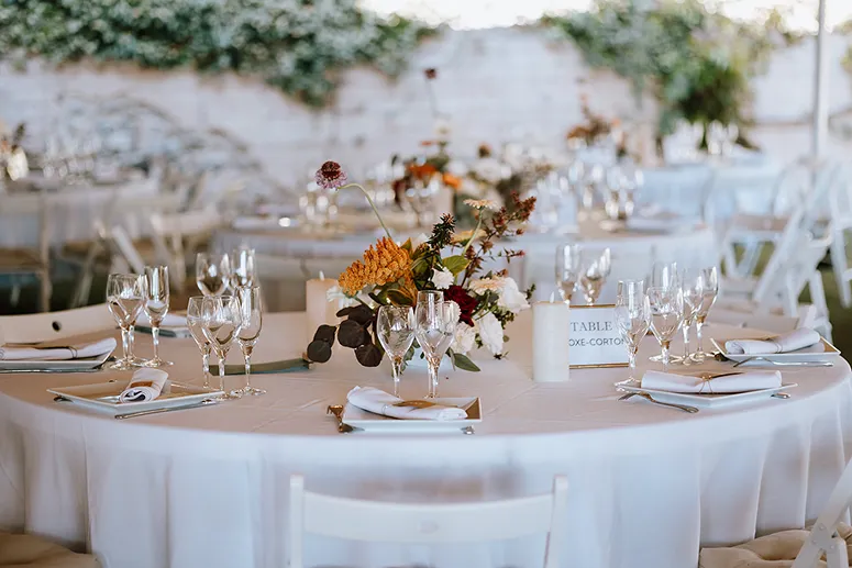 une table dressée avec une nappe blanche et un bouquet esthétique