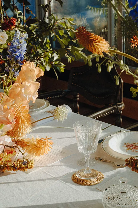 devant des bottes de foin se trouvent plusieurs fleurs composées de roses, violet, vert, jaune et rouge