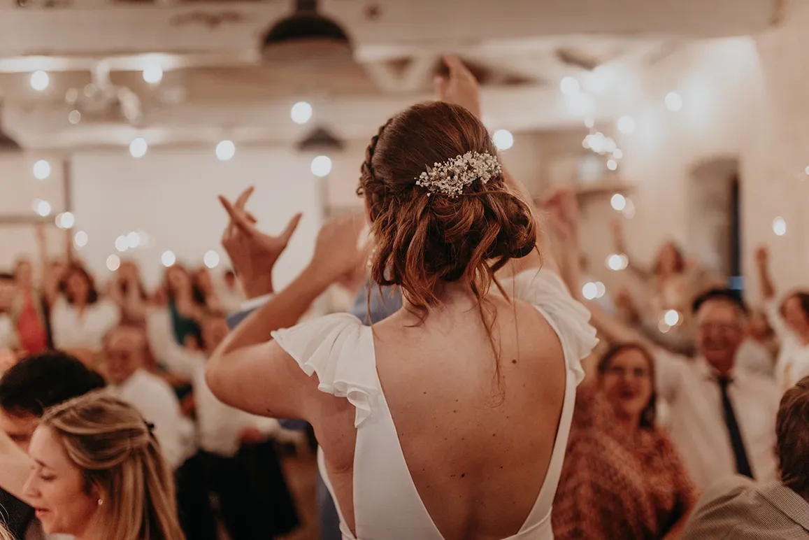 une photo prise lors d’un mariage pendant le repas de la mariée de dos